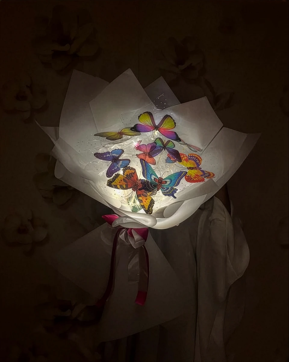 Heart-shaped arrangement of rich roses and golden chocolates presented on a velvet chair